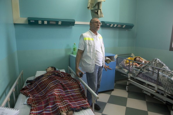 מנהל "אל-ופאא", בסמאן עלאשי, לצד שני חולים משותקים, 15.7.2014.  צילום: אן פאק